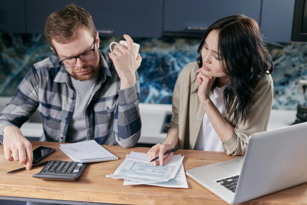 Couple calculating finances and deciding whether to invest or pay off debt