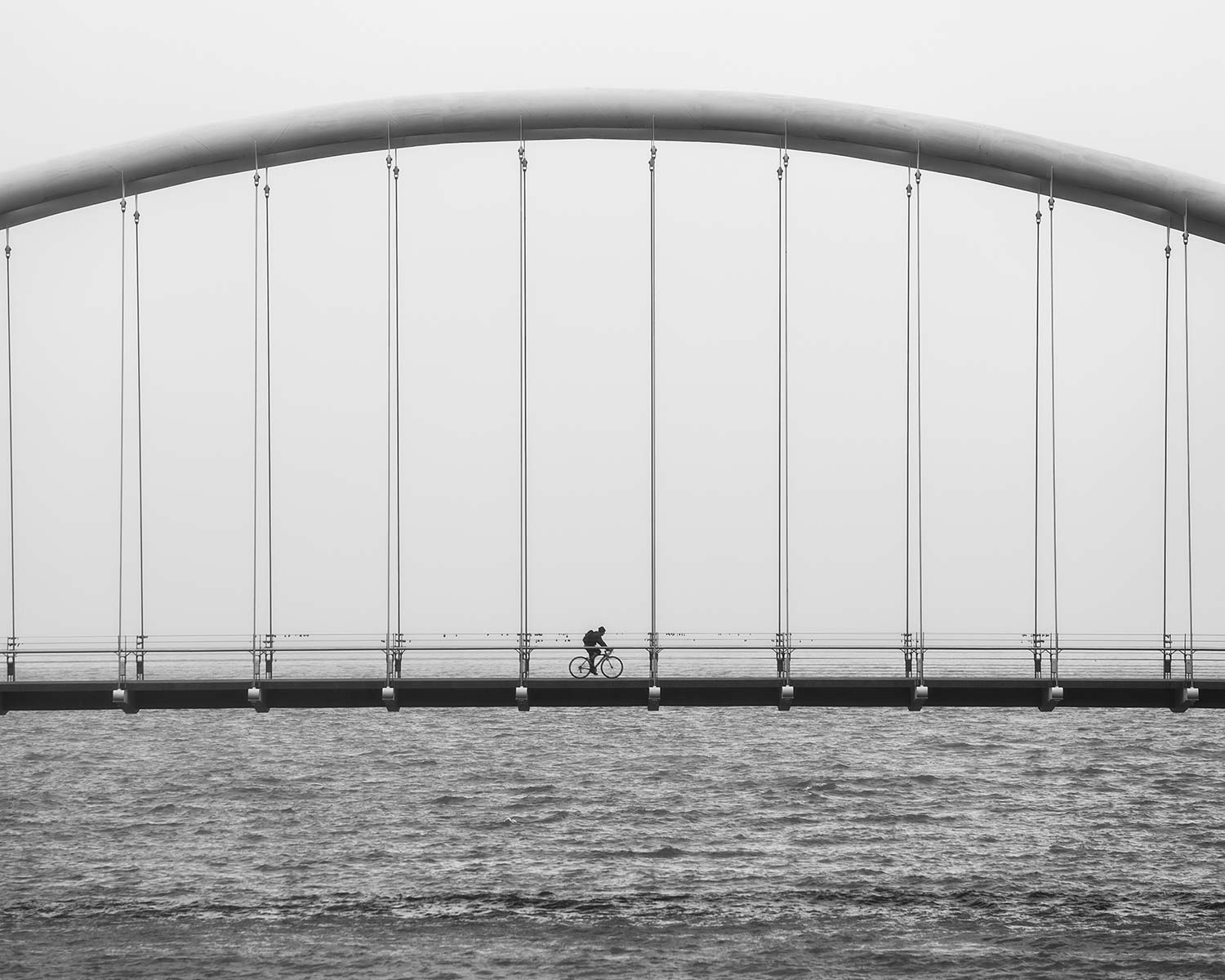 A bridge going over water with an arch.