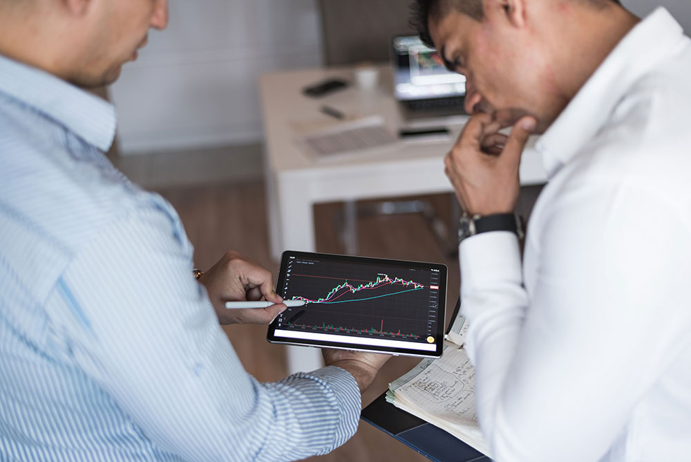 Pasadena financial planners watching investments on a tablet.