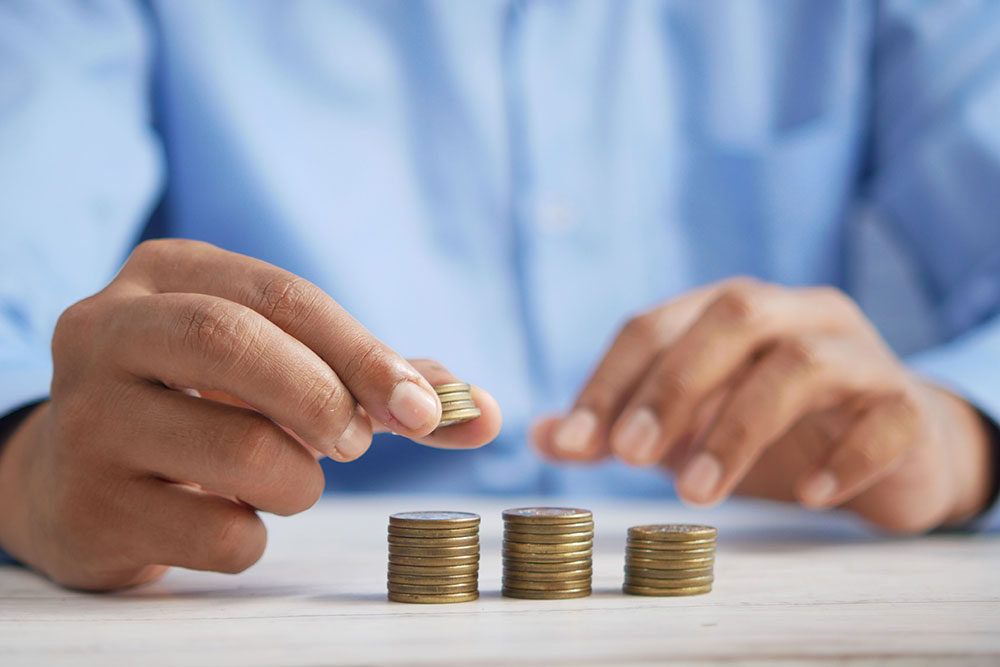 Person stacking coins on table