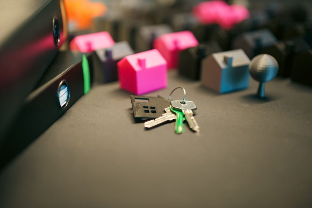 Miniature model houses with keys depicting REIT investments